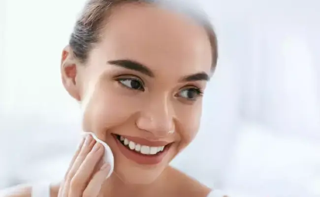 زنی در حال پاکسازی صورت