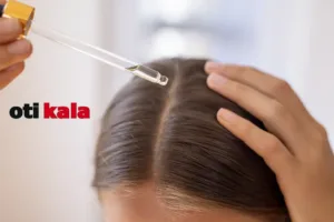 زنی در حال زدن روغن به موهایش