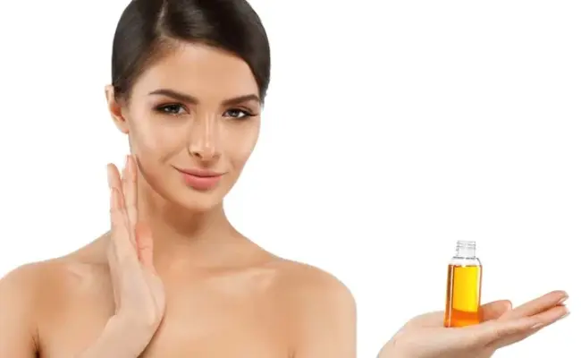 زنی در حال استفاده از روغن آرگان روی صورتش