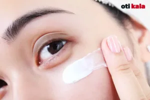 زنی در حال استفاده از کرم دور چشم