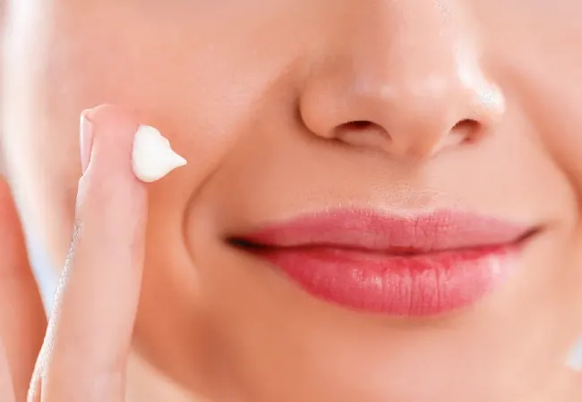 زنی در حال استفاده کرم برای جای جوش